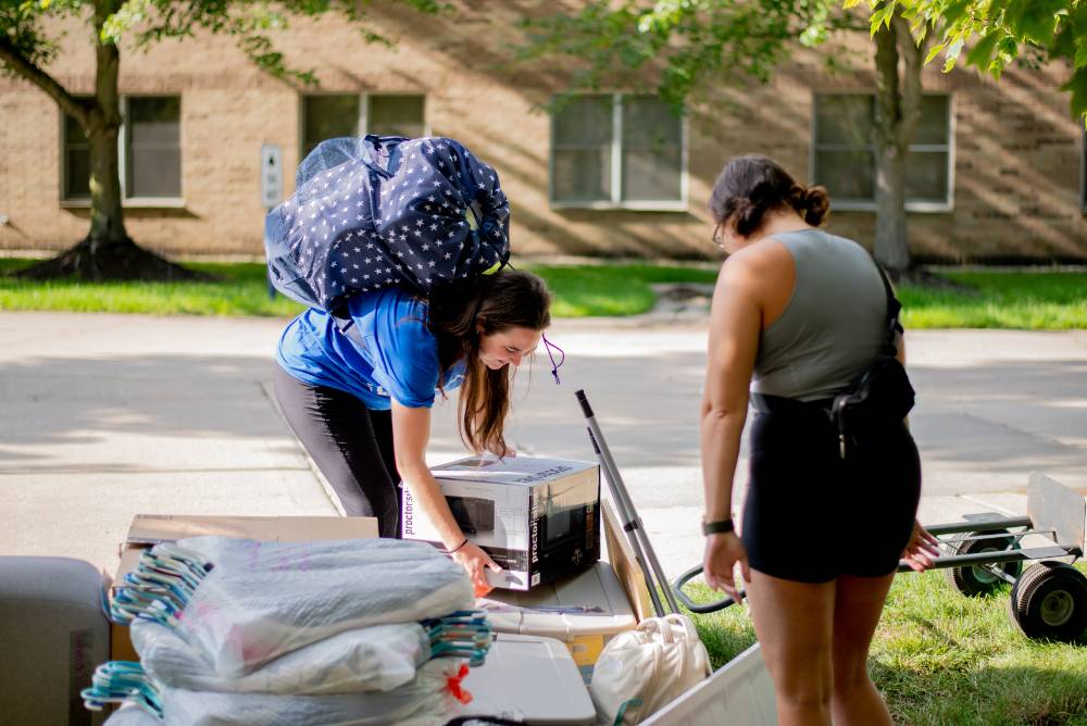 An Alumni helping a Laker move into their dorm.
